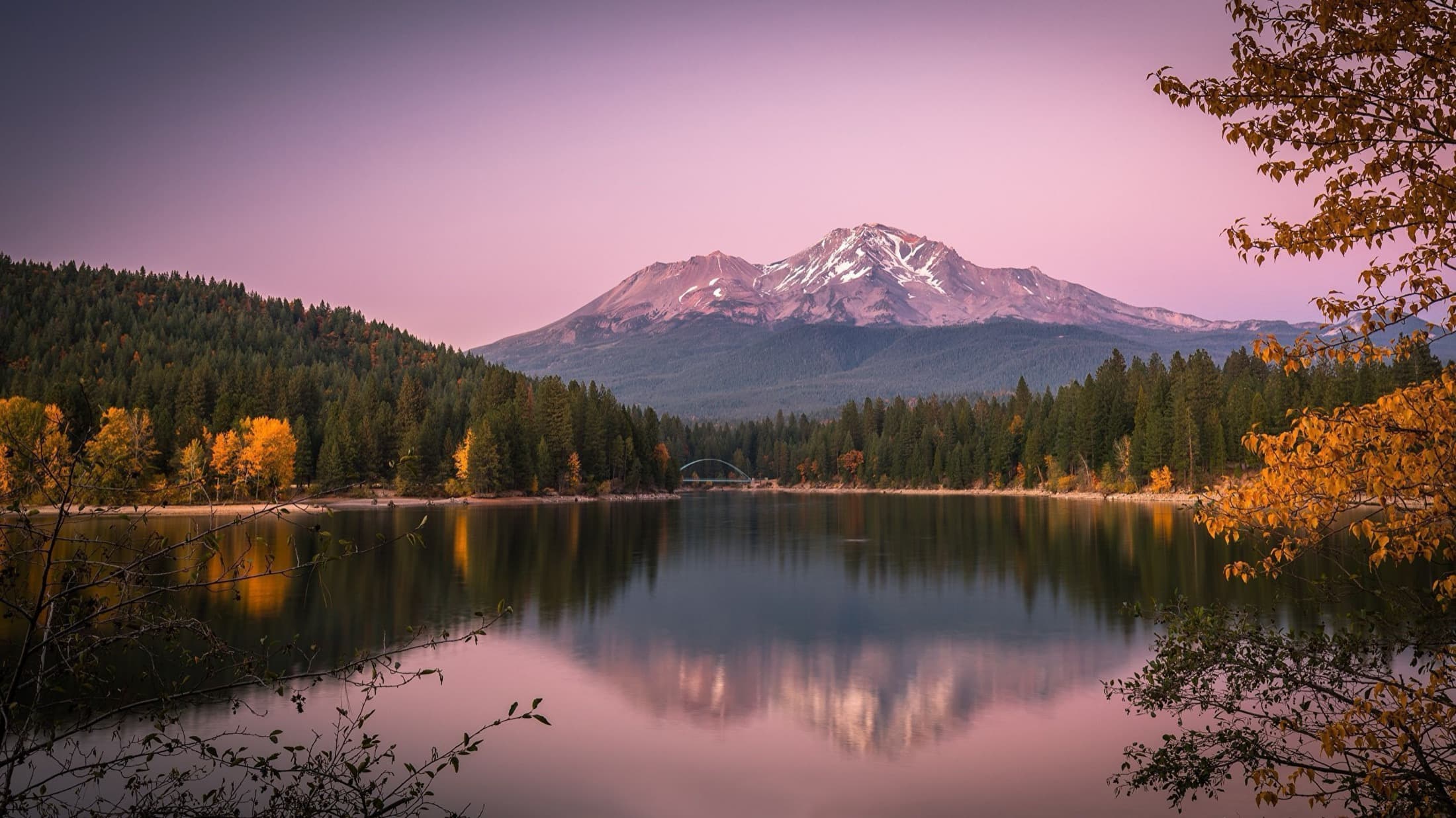 Mt. Shasta at pink alpenglow reflected over the lake