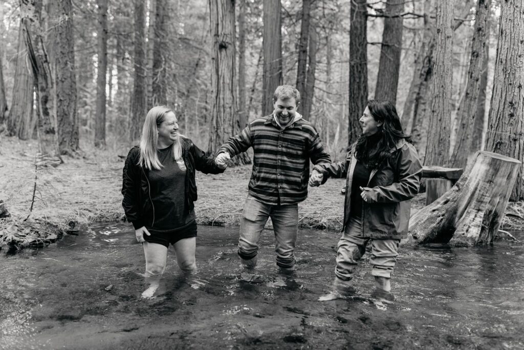Heather Moyer with retreat guests walking through a forest stream
